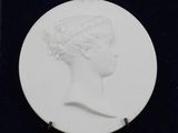an image of a picture of a woman ' s head on a white plaque