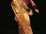 figurine of a man holding a golden cloth on a black background