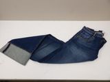 the pair of jeans are laying on the table next to each other
