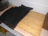 a pile of black cloth on top of a wooden cutting board