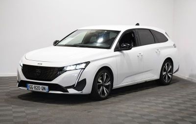 la voiture blanche est garée dans une pièce au sol en damier