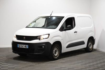 la camionnette blanche est garée dans une pièce au sol en damier