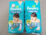 two packs of pampers baby dry diapers sitting on top of each other