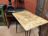 une petite table aux pieds en épingle à cheveux, dans un coin de la pièce