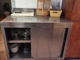a kitchen with a stainless steel counter and a basket on top of it