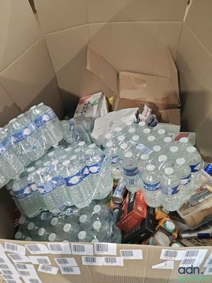 a cardboard box full of water bottles and other items