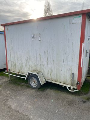 a white trailer with a red trim parked in a parking lot