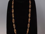 a black mannequin with a gold chain on it