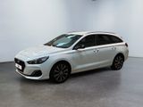 Une voiture blanche est garée dans une pièce blanche au sol noir.