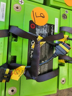 un tas de piles vertes munies d'étiquettes jaunes