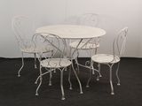 une table blanche et quatre chaises dans une pièce