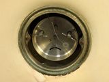 a metal clock with a face in the middle of it