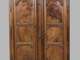 une vieille armoire en bois avec des gravures et des sculptures sur les portes