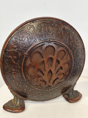 une assiette en bois décorée, posée sur un support