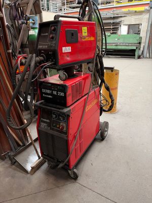 une machine rouge posée au sommet d'un tas de bois