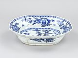 an old blue and white bowl with a floral design on it