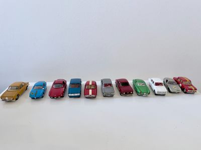 plusieurs petites voitures sont alignées sur une surface blanche