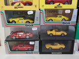 many different models of cars in boxes on the table