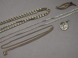 une collection de bijoux en argent comprenant un collier et un pendentif
