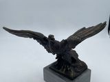 une image représentant une statue en bronze d'un oiseau posée sur un socle en marbre