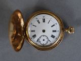 a gold pocket watch with roman numerals on it