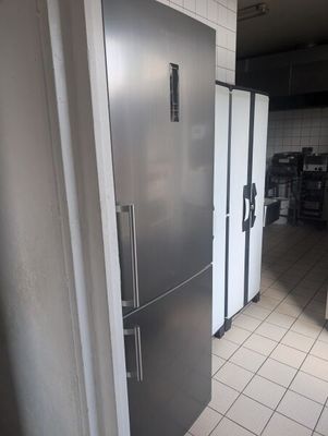 a silver refrigerator in the middle of a kitchen