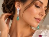the woman is wearing a white shirt and green earrings