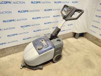 a close up of a floor scruber on the ground in front of a wall