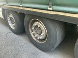 a green truck that has a flat tire on it