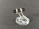 a small glass object with a pen on top of it