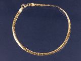 un gros plan d'un bracelet à maillons dorés sur fond bleu