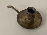 a small metal candle holder on a white table