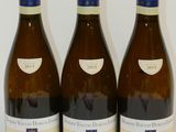 trois bouteilles de vin posées sur une table, l'une à côté de l'autre