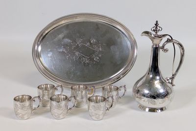 un plateau en argent sur lequel sont posés un pichet et des tasses en argent