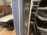 a metal locker with a door open next to a car