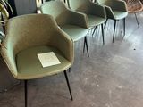 three green chairs sit in a row in a room with a balcony