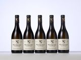 four bottles of wine are lined up on a table
