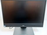 the dell monitor is sitting on a stand on a white surface