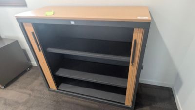 une photo d'une bibliothèque dans un coin d'une pièce