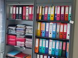 a room with a bookcase full of files and folders