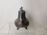 a silver bell sitting on a glass shelf in a room