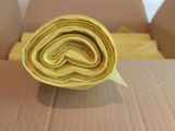 a roll of rolled up yellow fabric in a cardboard box