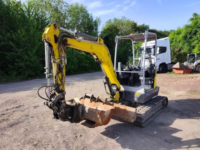 a yellow and black excavator sitting in the dirt