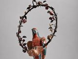 un oiseau perché sur une branche suspendue à une chaîne ornée de fleurs et de feuilles