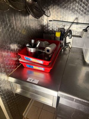 a red basket that is sitting on a metal counter
