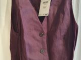 a purple dress hanging on a hanger in front of a white curtain