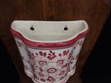 a white vase with red and white flowers on it