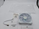 a small fan sitting on a white table next to a laptop computer