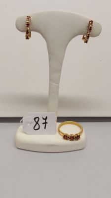 deux bagues en or et une bague en or posée sur un socle blanc