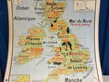 an old map of the british isles on display in front of a blue wall